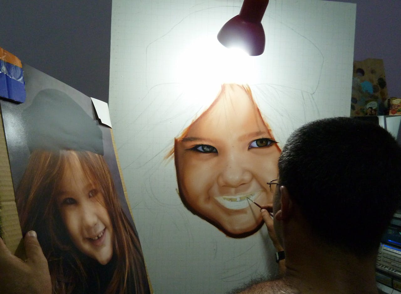 Home Artist paints a realistic portrait of a smiling child under a lamp.