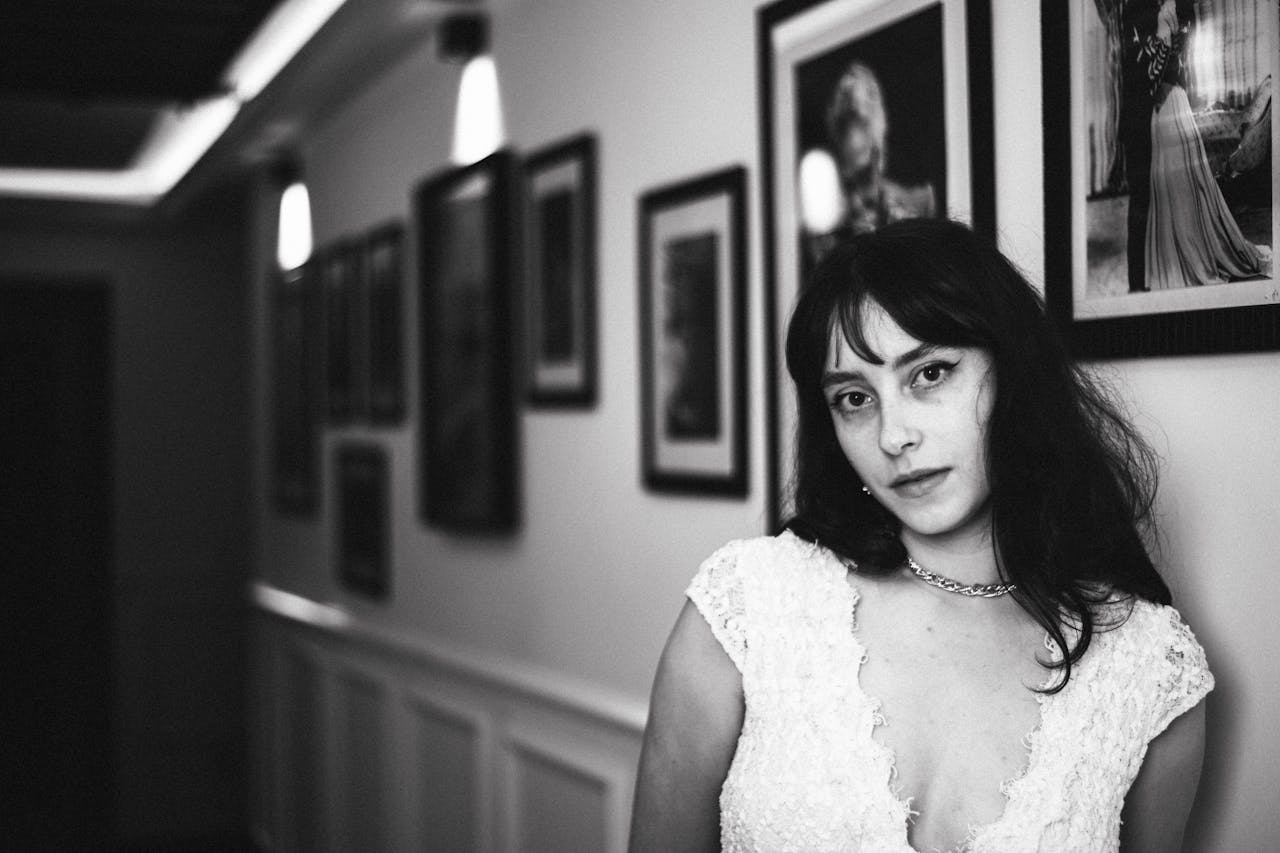 Home Elegant black and white portrait of a woman in a vintage-inspired hallway setting.